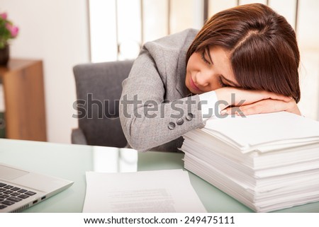 Pretty young business woman taking a nap after too much work at the office