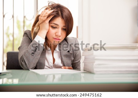 Very unhappy and overwhelmed business woman with too much work to do at her office
