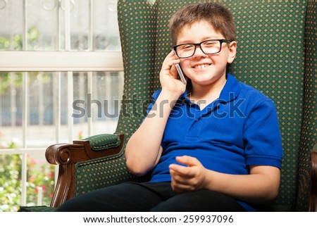 Happy little boy using a cell phone to talk to his best friend