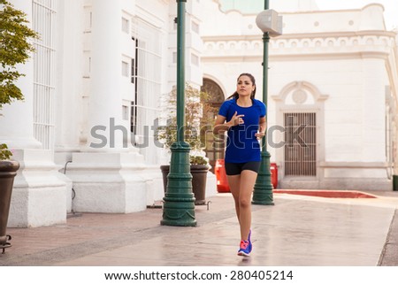 Full length portrait of a young female runner training in the city
