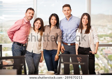 Portrait of a group of five people in a meeting room, dressing casually and smiling