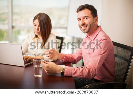 Portrait of an attractive young man working in an office and smiling