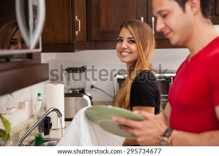 Gorgeous young woman and her boyfriend doing some house chores together