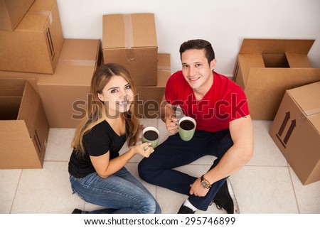 Good looking Latin couple moving in together and drinking some coffee