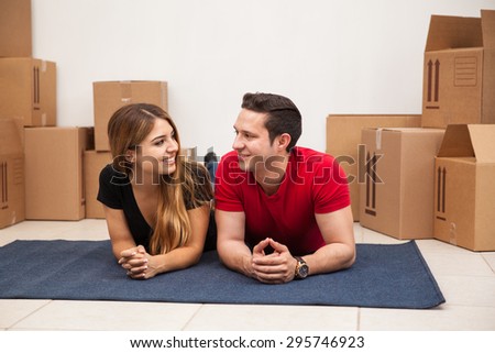 Latin young couple taking a break from unpacking in their new home