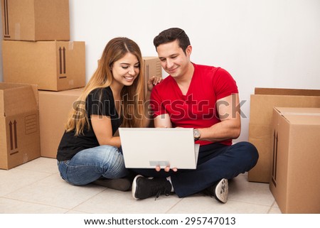 Cute young couple moving out of their home and searching online for a new place