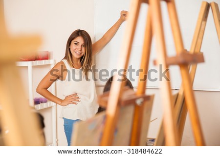 Portrait of a cute Hispanic teacher giving some instructions to her students for art class