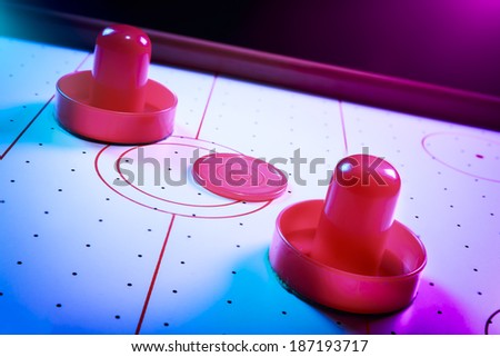 Air hockey table with dramatic lighting on a dark background