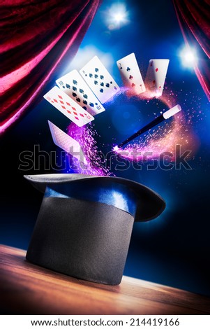 photo composite of a magic hat on a stage with cards and a magic wand