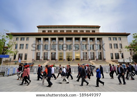 Beijing, China- April 20, 2014: Tourists in a group passing by the Great Hall of the People. a meeting place for the Chinese Communist Party and National People\'s Congress. Built in 1959.
