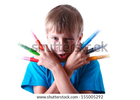 Beautiful angry blond boy in a blue t-shirt holds colorful felt-tip pens and poses as a movie hero
