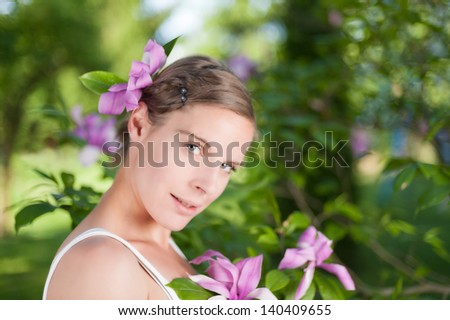 Beautiful woman under a magnolia tree, enjoying the serenity of spring