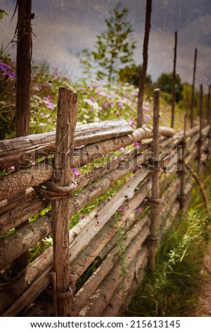 Traditional wooden fence along a dirt road in the swedish countryside