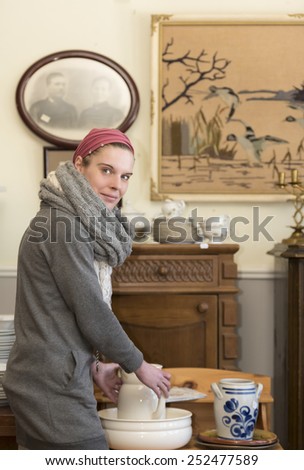 Attractive woman visiting an antique shop and looking for precious nice things