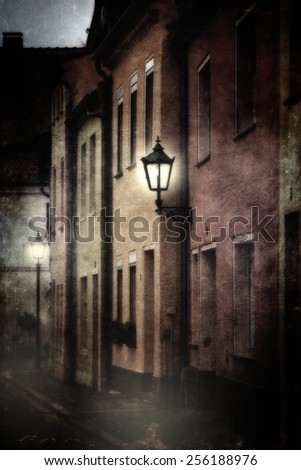Mysterious street scene with luminous lanterns in the dark. Photo with textures to achieve a mystical, mysterious impression.