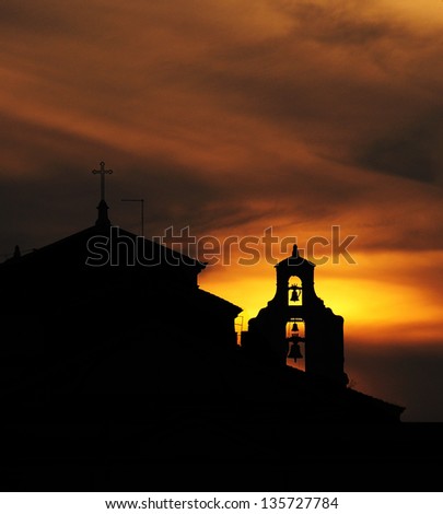 Sunset over the silhouette of church\'s bell tower. Taken in Rome, Italy at dusk.