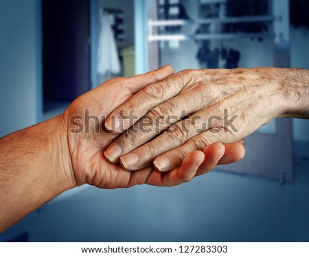 Elderly care and senior health services with the hand of a young person holding and helping an old and aging patient for in home medical help due to aging and memory loss in a hospital background.