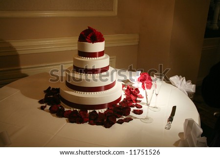 Wedding cake under low romantic light with petals around it