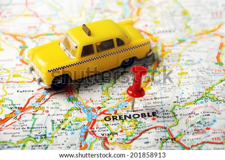 Red push pin pointing at Grenoble , France  map   and a taxi