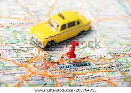 Close up of Stuttgart  map with red pin and a taxi  - Travel concept