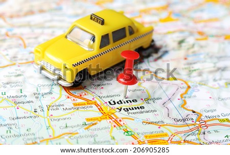 Close up of  Udine  , Italy map with red pin and a taxi   - Travel concept