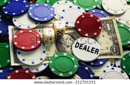 Dollar bill ,casino chips and dice hidden under  question mark- risk concept