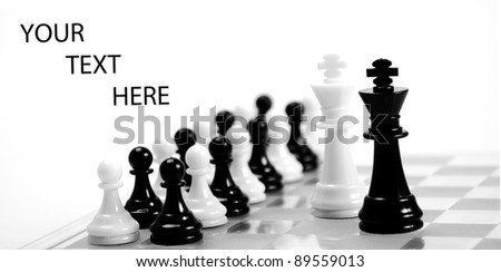 White and black king on the chessboard opposing each other,black and white pawns in the background,can be used as concept for conflict, meeting, agreement..
