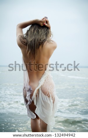sexy girl with a figure standing at the sea showing her ass