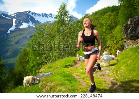 girl on a morning jog in the summer outdoors. goats in the mountains. in the picturesque fjords of Norway
