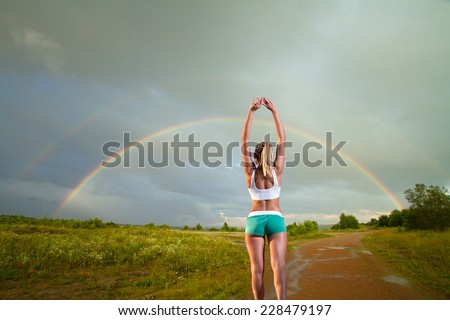 girl on a morning jog in the summer outdoors .Rainbow in the blue sea