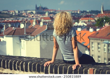 girl sitting on the roof of a house in Prague. top view of the city. top view . lifestyle