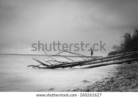 woman is standing with his back to the coast. Dramatic black and white portrait
