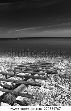 black and white photography. sea and the horizon and the sand and rocks and stairs