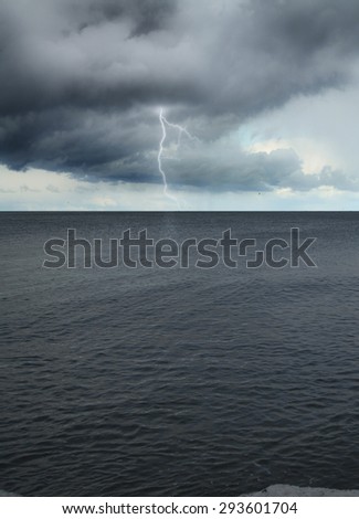 Lightning into the sea during a storm. dark clouds over water