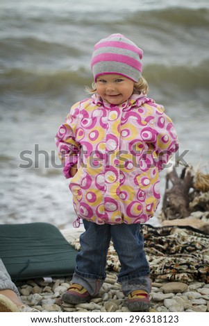 Girl in the autumn at the sea . walking on rocks in the ocean background