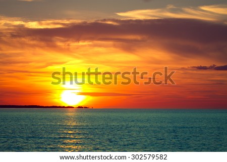 sunset on the sea. red and orange sun and blue water