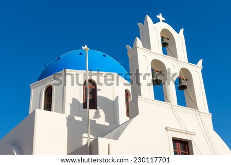 White church with a blue roof seen in Oia, Santorin, Greece