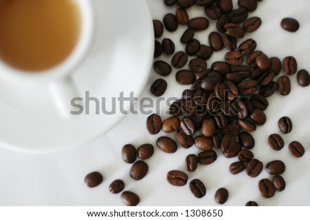coffee beans and coffee cup close-up (cup is out of focus)
