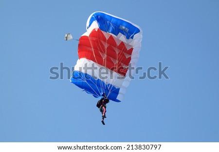 Blue white and red sail parachute on blue sky