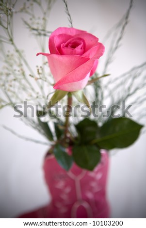 A pink rose in a little cowgirl boot.