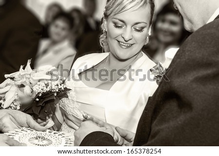 Groom Happy putting ring on smiling pretty woman bride\'s finger, Black and white stock photo