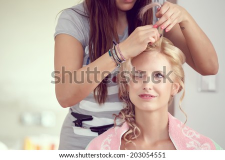 hair stylist designer making hairstyle for woman bride in wedding day