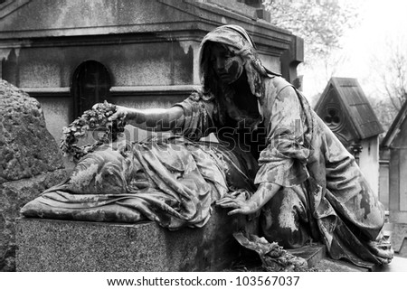Sculptures from the Pere Lachaise Cemetery Paris, France (dark key photo)