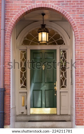 Green Front Door with White Ornate Archway Door Frame in Brick Building