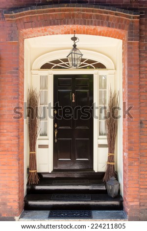 Black Front Door with White Door Frame in Brick Building and Decorative Bunches of Branches