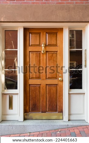 Natural Wood Door with Gold Fixtures and Side WIndows in White Door Frame
