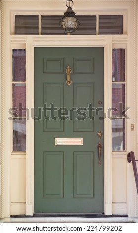 Green Front Door with Surrounding White Door Frame and Windows with Hanging Lamp Overhead