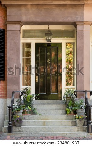 Black Front Door with Portico and Steps on Brick Street