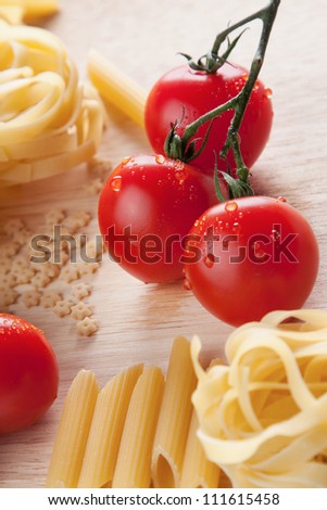 Wet cherry tomatoes and an assortment of different pastas, ingredients for healthy Italian cuisine