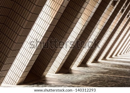 Pillars on the outside of the Cultural Center in Hong Kong allow light to illuminate a corridor with alternating bands of lightness and darkness.